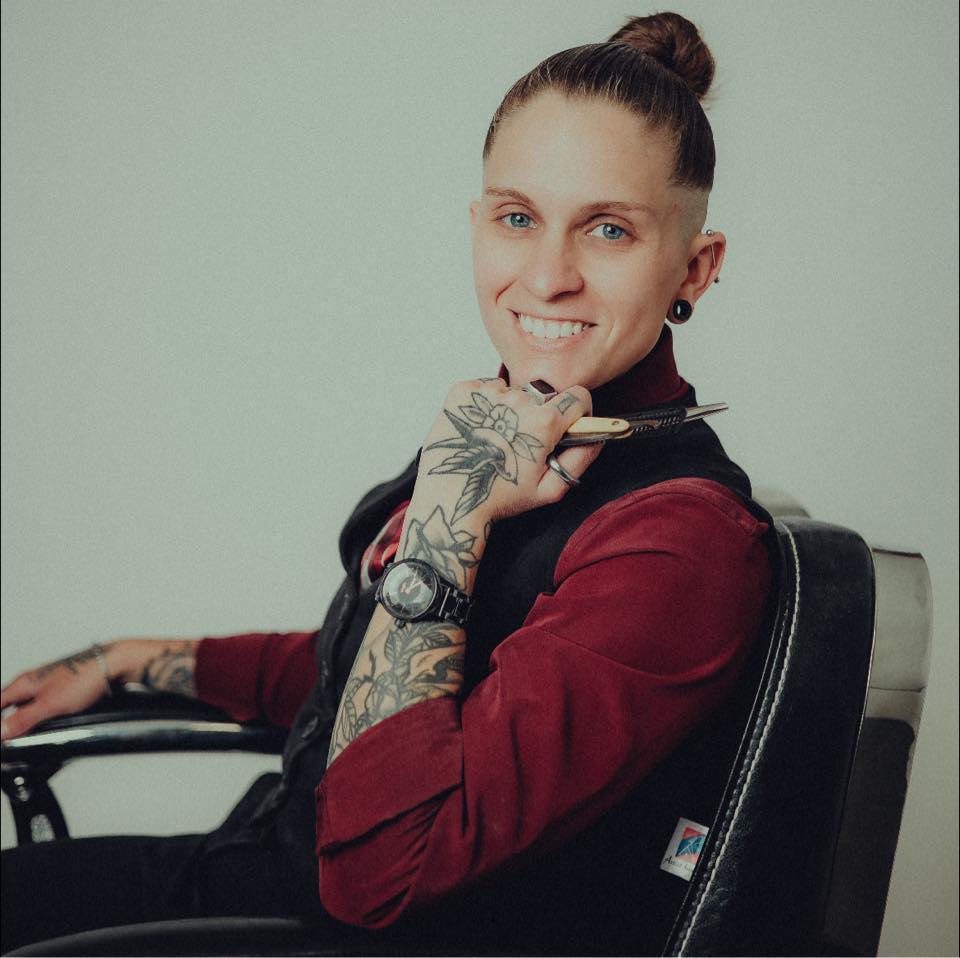 Nae, owner and award-winning barber at The Edge Barbershop, portrait with scissors